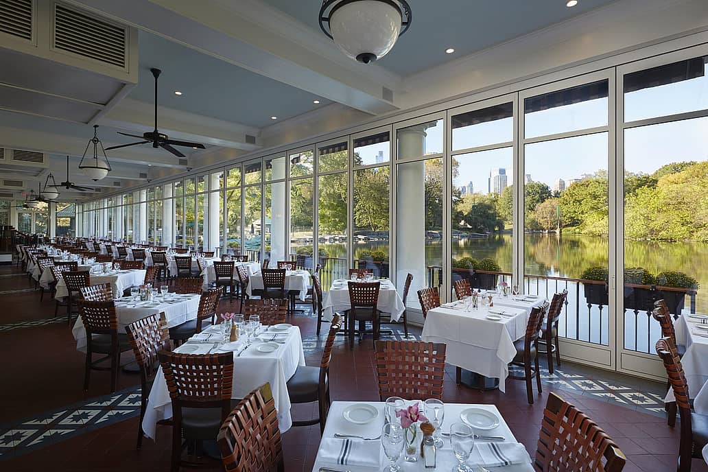 The Loeb Boathouse Central Park, New York, NY | Restaurant with floor-to-ceiling sliding glass doors overlooking a scenic lake. 
