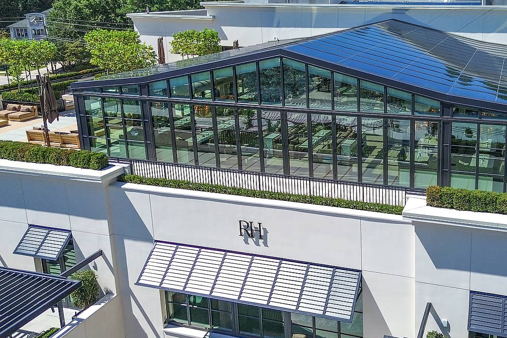 Restoration Hardware rooftop restaurant in Raleigh NC featuring modern white building with NanaWall SL70 bifold glass doors, large windows, and glass-enclosed rooftop dining area.
