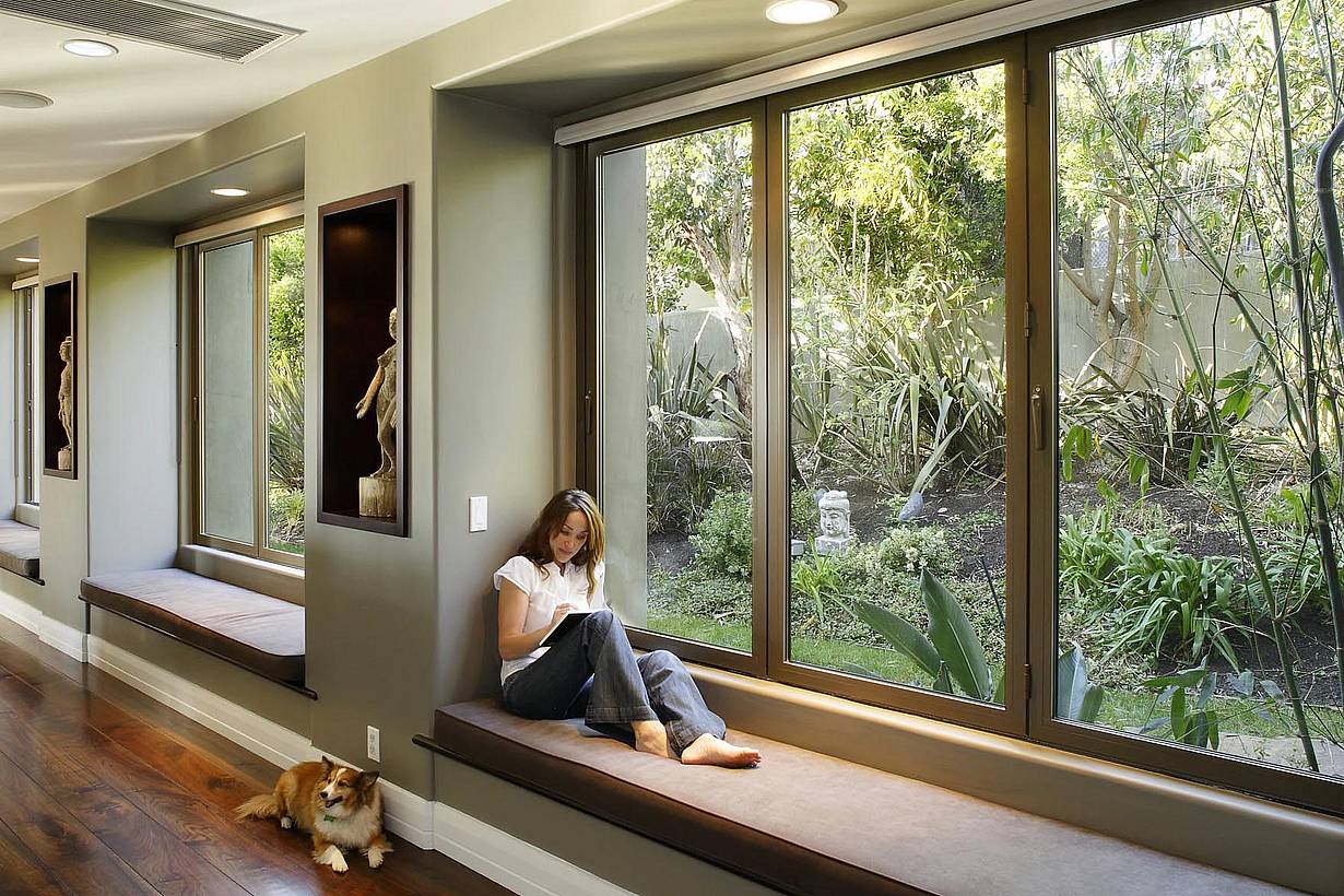 Woman exploring ideas in front of folding glass window
