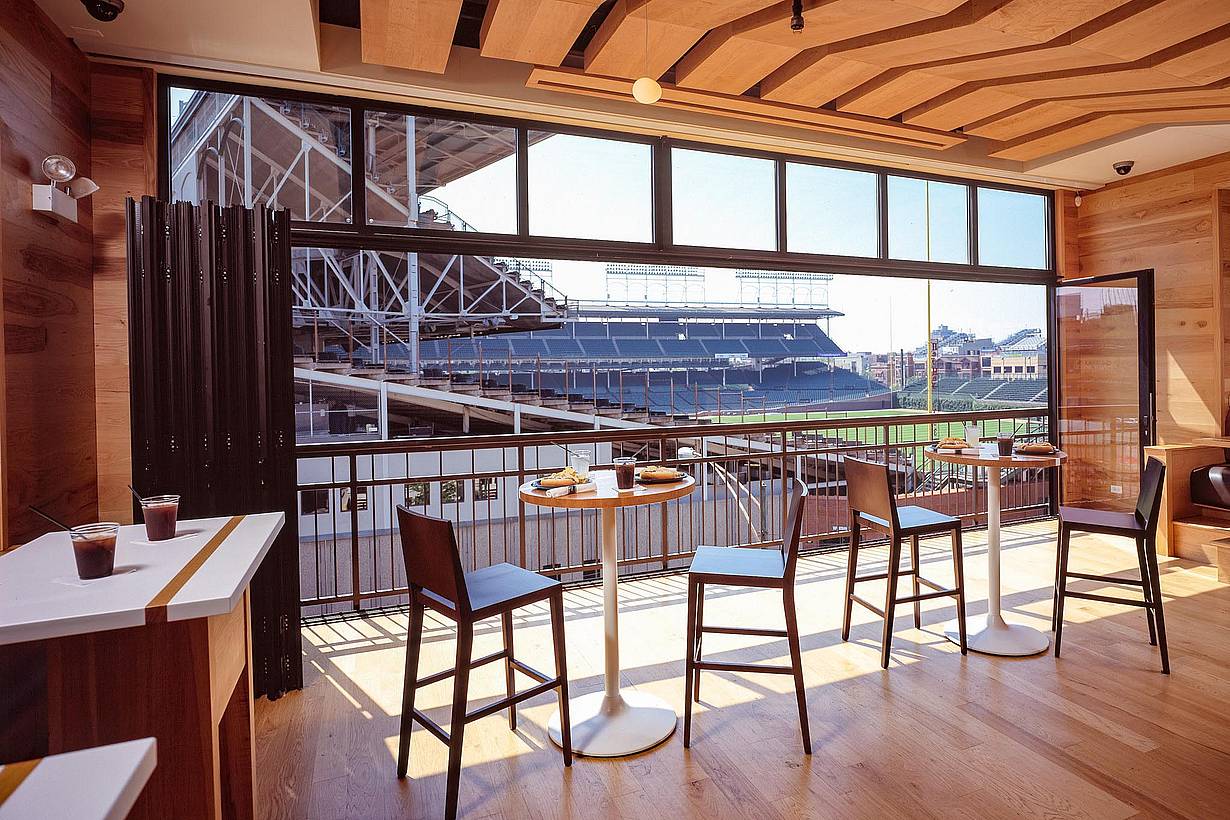 wrigley rooftops hospitality venue with folding glass wall open for view of baseball field