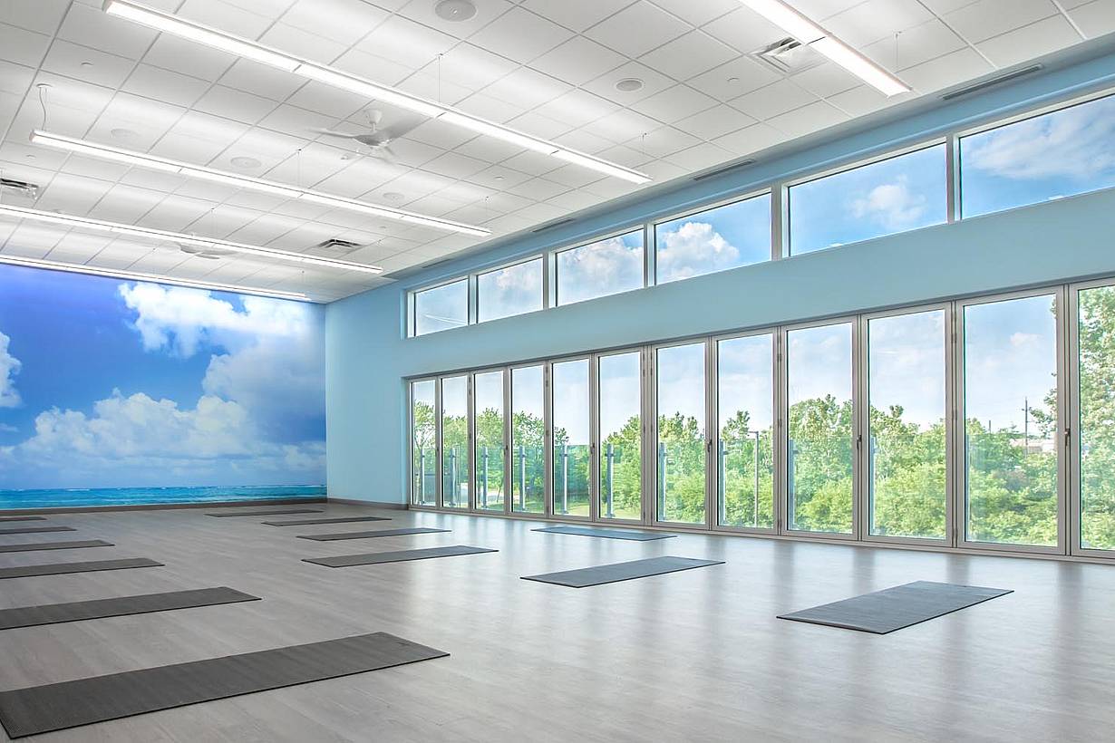 Movati athetlectic facility yoga room with closed folding glass wall