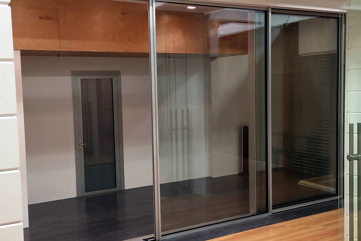 Modern interior with sliding glass doors, dark flooring, and a closed door, offering seamless style and automation potential.