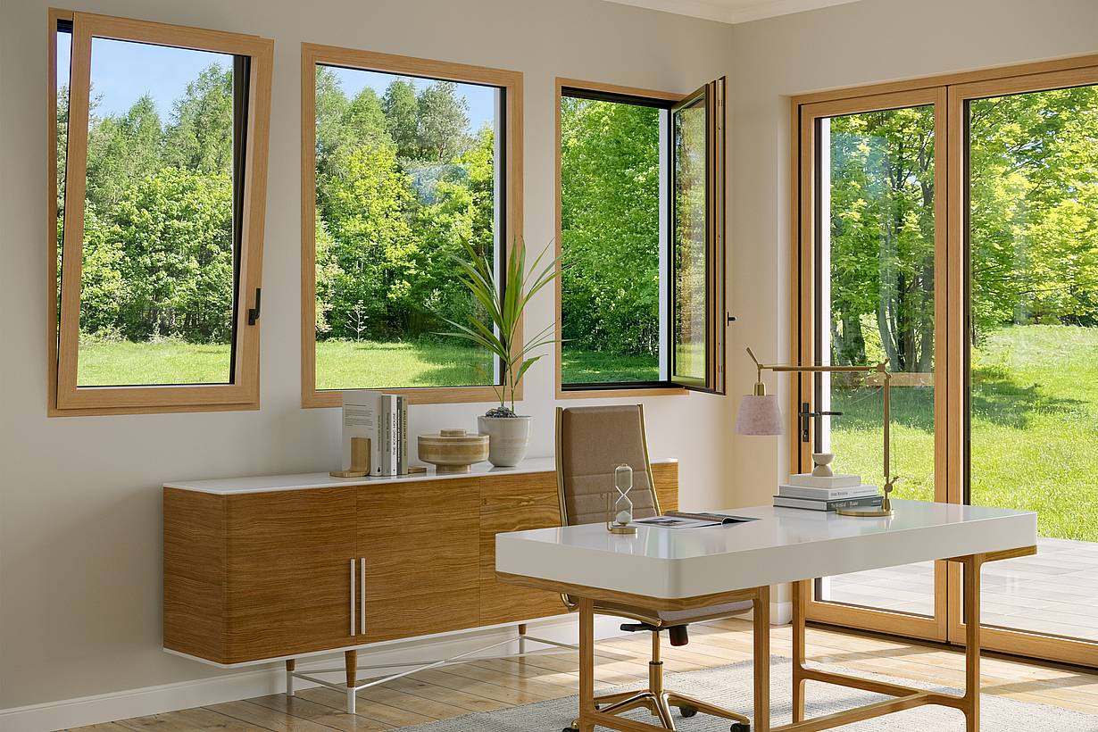 An office with a wooden table features Generation 4 folding glass walls and tilt turn windows, offering a uniform aesthetic and framing views of trees with yellow autumn leaves outside.