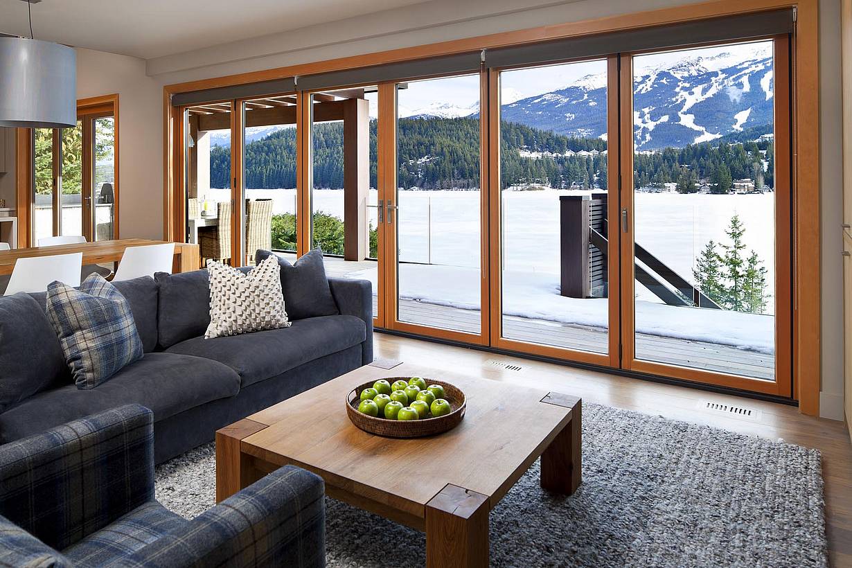 Retractable patio doors at a Whistler, BC home offer energy efficiency and seamless indoor-outdoor living by the lake