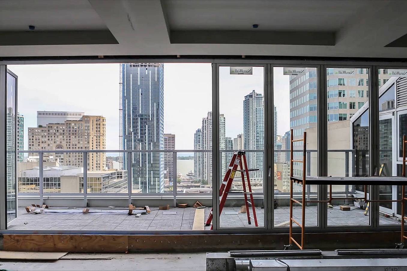 Interior of high-rise under construction with large glass windows and doors installed by NanaWall certified installation network.