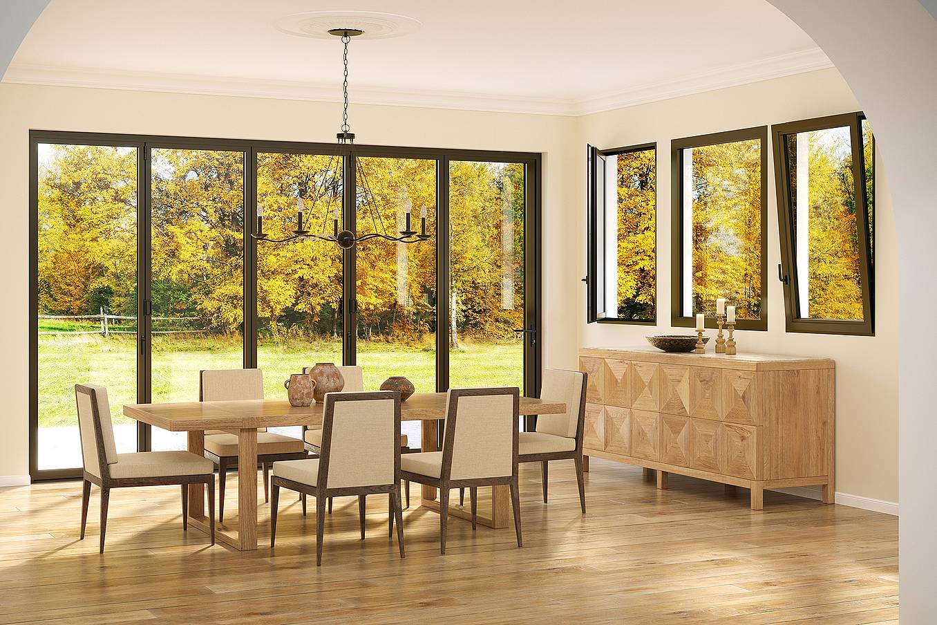 A dining room with a wooden table, six chairs, and a sideboard features Generation 4 folding and sliding glass walls and tilt turn windows, offering a uniform aesthetic and framing views of trees with yellow autumn leaves outside.