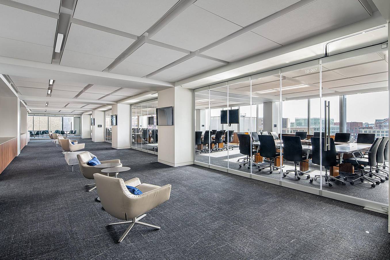 Modern office with a conference room separated by closed sliding glass walls featuring a single-track sliding system.